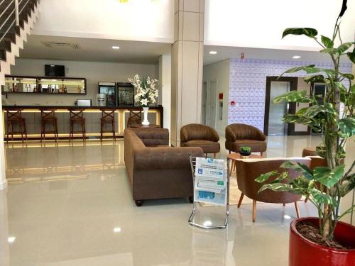 a lobby with couches and a table and chairs at Hotel Gran Santa Catarina in Indaial
