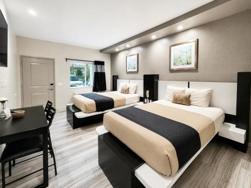 a hotel room with two beds and a desk and a desk at Crystal Inn Downtown in Houston
