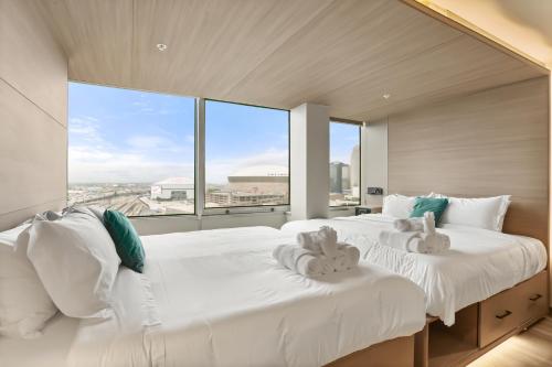 two white beds in a room with a large window at VCAY Hotel 5BR 5BA Group Suite Near Superdome in New Orleans