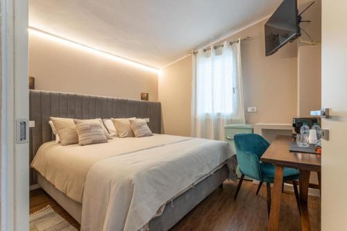 a bedroom with a bed and a table with a chair at valter rooms 3 in Castel del Piano
