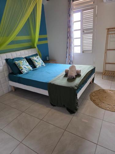 a bedroom with a bed with a stuffed animal on it at Bleu Caraïbe in Sainte-Anne