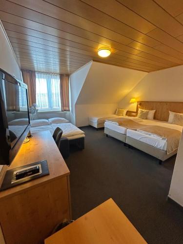 a hotel room with two beds and a flat screen tv at Hotel Restaurant Adler in Westhausen