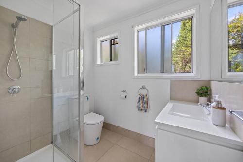 a bathroom with a shower and a toilet and a sink at Prom Coast - Seabreeze in Sandy Point