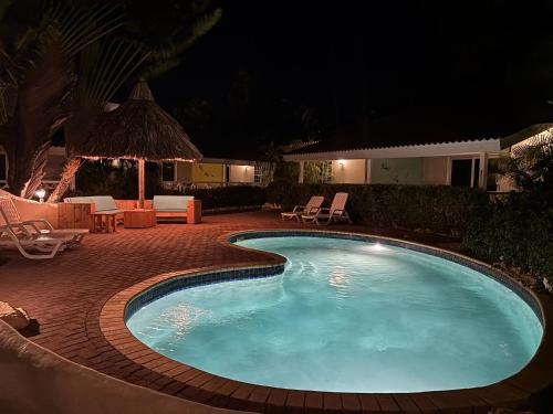 a swimming pool in a yard at night at Blue Marlin Apartments, nabij Mambo Beach in Willemstad