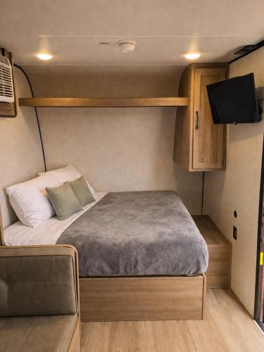 a small bedroom with a bed in a caravan at Grand Canyon RV Glamping in Williams