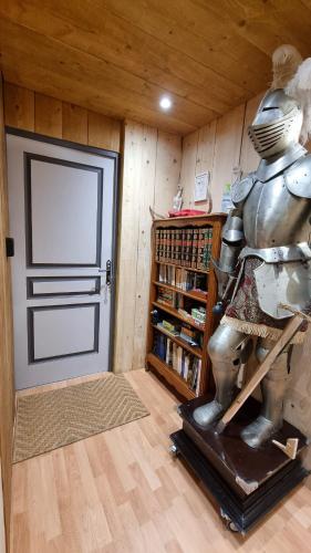 a room with a door and a statue next to a book shelf at le relais de l'abelan in Blesle
