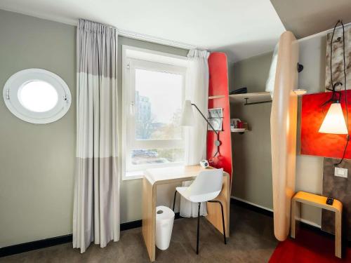 a small room with a desk and a window at ibis Portsmouth in Portsmouth