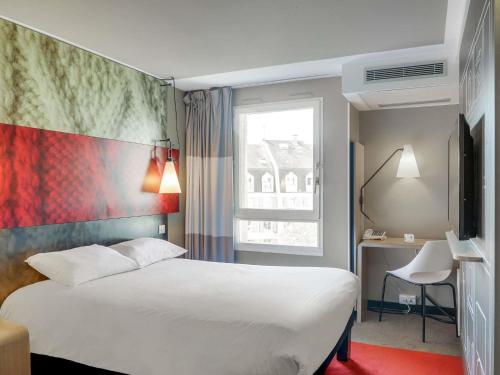 a hotel room with a white bed and a window at ibis Rueil-Malmaison Centre in Rueil-Malmaison