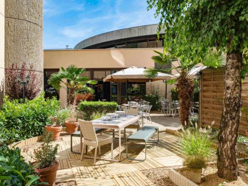 a patio with a table and chairs in front of a building at ibis Tours Centre Gare in Tours