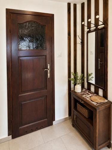 a bathroom with a wooden door and a mirror at Pokój dyrektora stadniny in Niezgoda