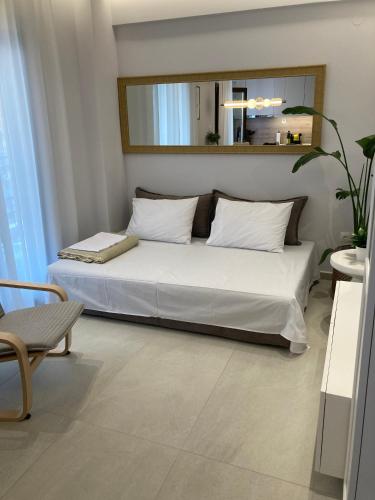a bedroom with a white bed with a mirror at La casa di Zoe in Flogita