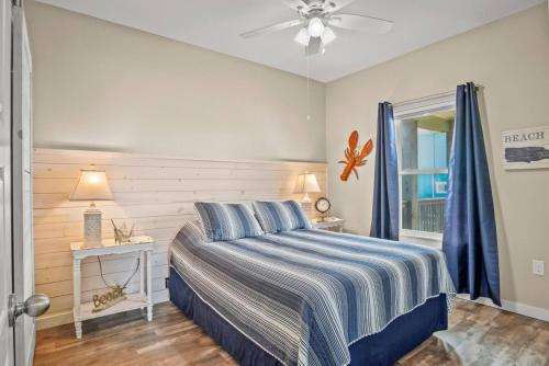 a bedroom with a bed with a blue and white striped blanket at Mills Fishing Cabin in Port Aransas