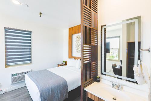 a bedroom with a bed and a sink and a mirror at Urban Boutique Hotel- Little Italy, Downtown San Diego in San Diego
