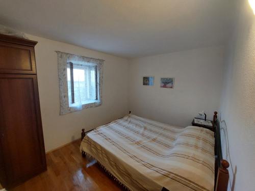 a bedroom with a bed and a window at Holiday Home Tomislav in Komiža