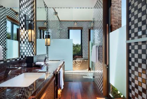 a bathroom with a sink and a mirror at Garrya Bianti Yogyakarta in Yogyakarta