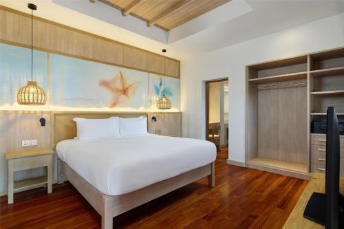 a bedroom with a white bed and a tv at Garrya Tongsai Bay Samui in Choeng Mon Beach