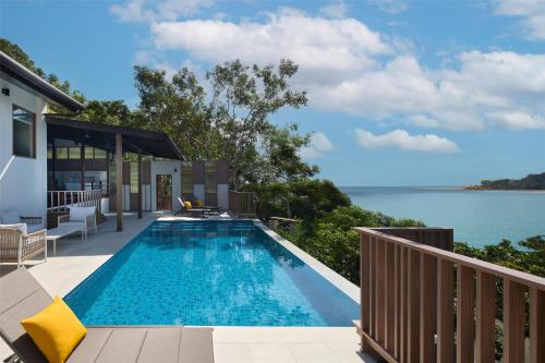 a swimming pool with a view of the water at Garrya Tongsai Bay Samui in Choeng Mon Beach