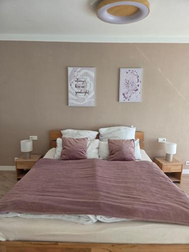 a bedroom with a large bed with a purple blanket at Brenz City Stay in Heidenheim an der Brenz