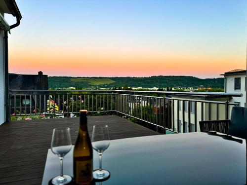 a bottle of wine and two glasses on a table at JUPAS - Premium Apartments Trier in Trier