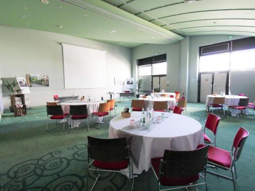 a conference room with tables and chairs and a whiteboard at ibis Styles Evry Courcouronnes Hotel and Events in Courcouronnes