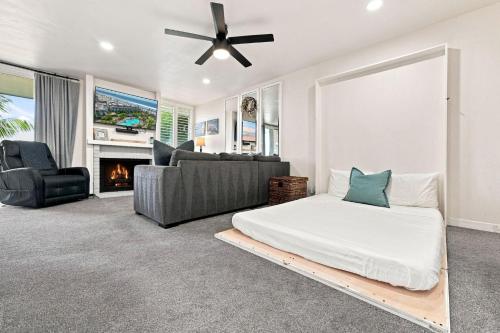 a bedroom with a bed and a couch and a fireplace at G6 - Answered Prayers Cottage in Oceanside
