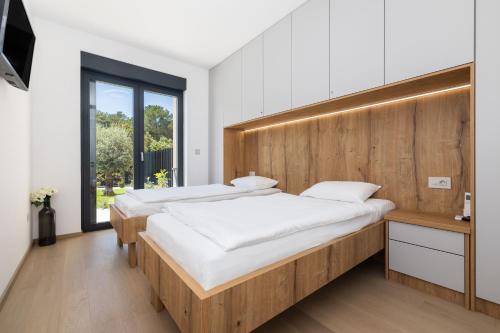a bedroom with two beds and a window at Andrea Deluxe Apartment with Pool in Mali Lošinj