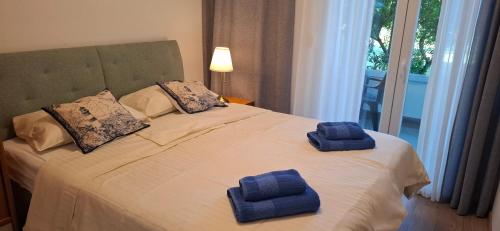 a bed with two towels on top of it at Rab Apartments Žic in Kampor