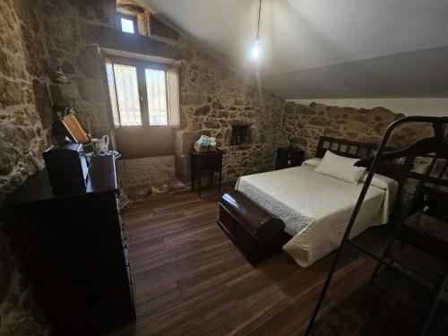 a bedroom with a bed in a room with stone walls at El Lagar de Mailusa in Sayar