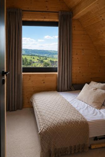 a bedroom with a bed and a large window at Domki na Gawlakach , z sauną i widokiem na góry in Zakopane
