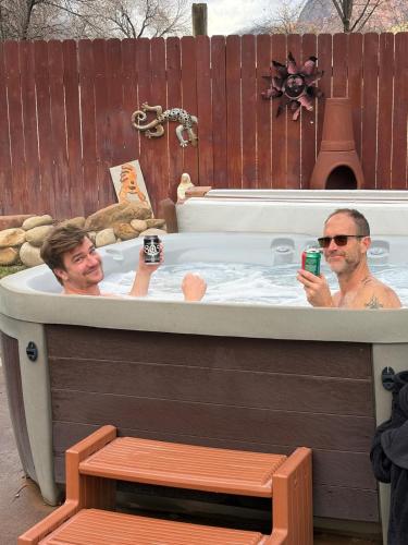 two men in a jacuzzi tub in a fence at Harvest House Inn in Springdale
