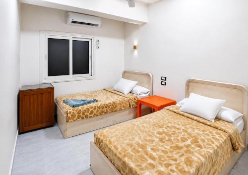 a room with two beds and a window at Gannet Alyousef City Center in Naj‘ al Maḩaţţah