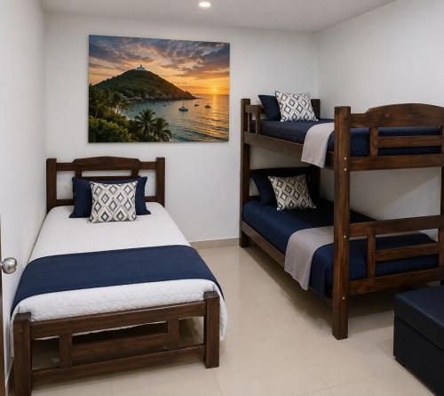 a bedroom with two bunk beds and a painting on the wall at Hostal Santa Maria City in Santa Marta
