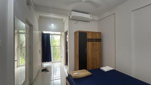 a room with a blue bed and a window at Stay near to temple 240m in Guruvāyūr