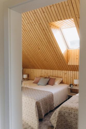 a bedroom with two beds and a skylight at Projekt Babia - Domek z jacuzzi in Lipnica Wielka