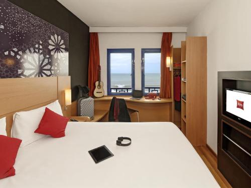 a hotel room with a bed and a desk at Ibis El Jadida in El Jadida