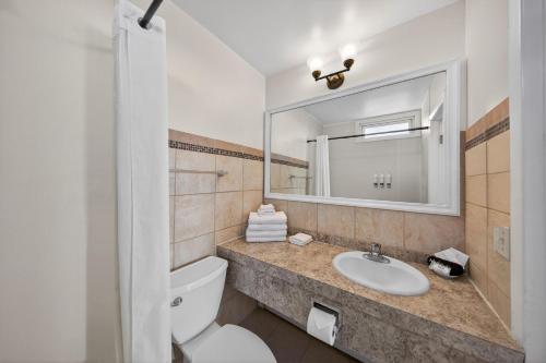 a bathroom with a toilet and a sink and a mirror at Ocean Surf Resort in Montauk