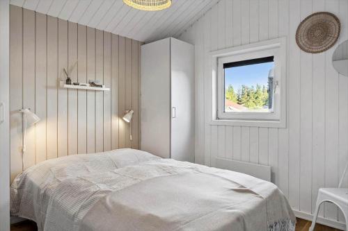 a white bedroom with a bed and a window at 1005-Thisted-Spanggardsvej-39 in Torsted