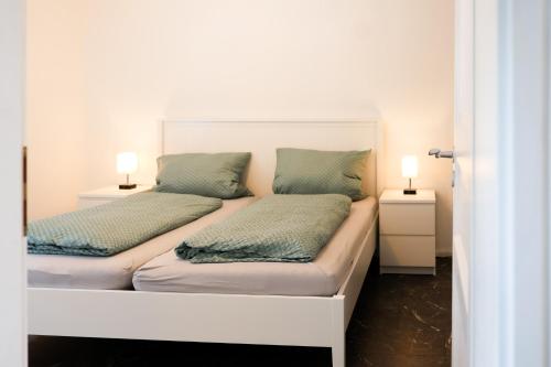two beds in a room with two lamps on them at Fewo zum Ritzli in Ettenheim
