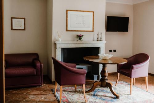 a living room with a table and chairs and a fireplace at Albergo dell'Agenzia in Bra