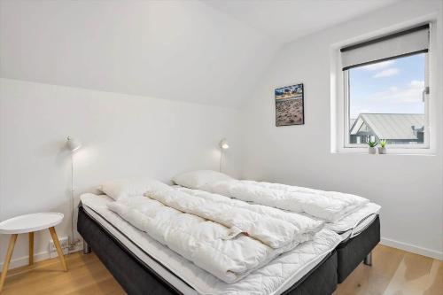 a bed in a white room with a window at 791-Thisted-Havstokken-12-1 in Thisted