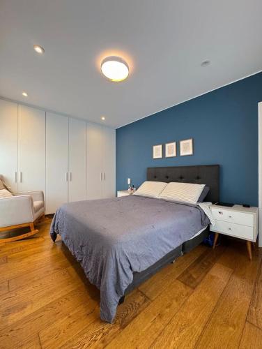 a bedroom with a large bed with a blue wall at David House 3BR Pent Mira in Lima