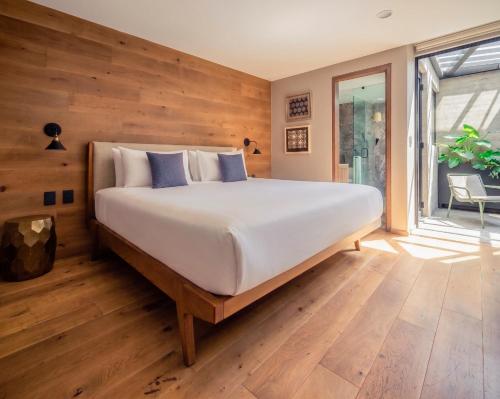 a bedroom with a large bed and a window at Frida by Viadora in Mexico City