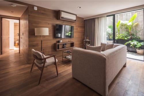 a living room with a couch and a chair at Frida by Viadora in Mexico City