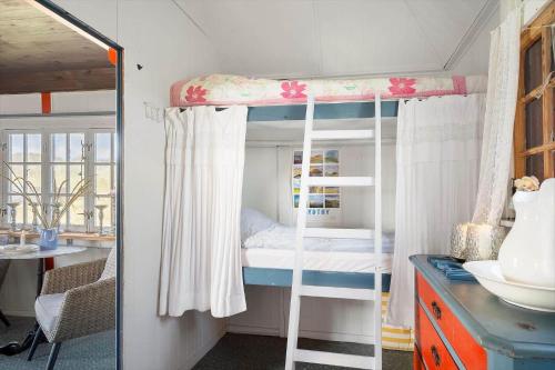a bedroom with a bunk bed and a bathroom at 1355-Vestervig-Klitvej-4 in Agger