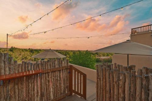 a wooden fence with an umbrella and an umbrella at Restored Adobe Casita Big Views Walk to Plaza in Santa Fe