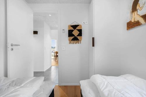 a bedroom with white walls and a white bed at 9954-Hvide-Sande-Langsand-214 in Hvide Sande
