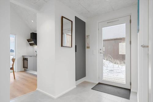 a white hallway with a door leading to a kitchen at 9954-Hvide-Sande-Langsand-214 in Hvide Sande