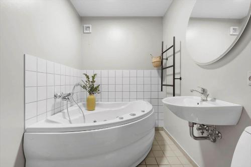a white bathroom with a tub and a sink at 7726-Hvide-Sande-Slusen-26 in Hvide Sande