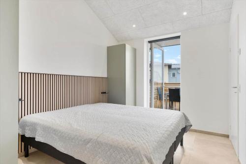 a bedroom with a bed and a large window at 782-Hvide-Sande-Norregade-2-nr-25 in Hvide Sande