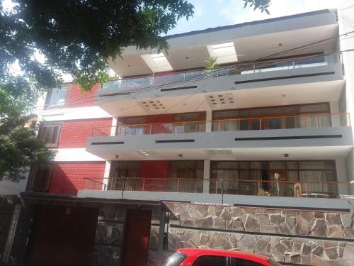 un edificio de ladrillo rojo con un coche rojo aparcado delante de él en Miraflores en Lima